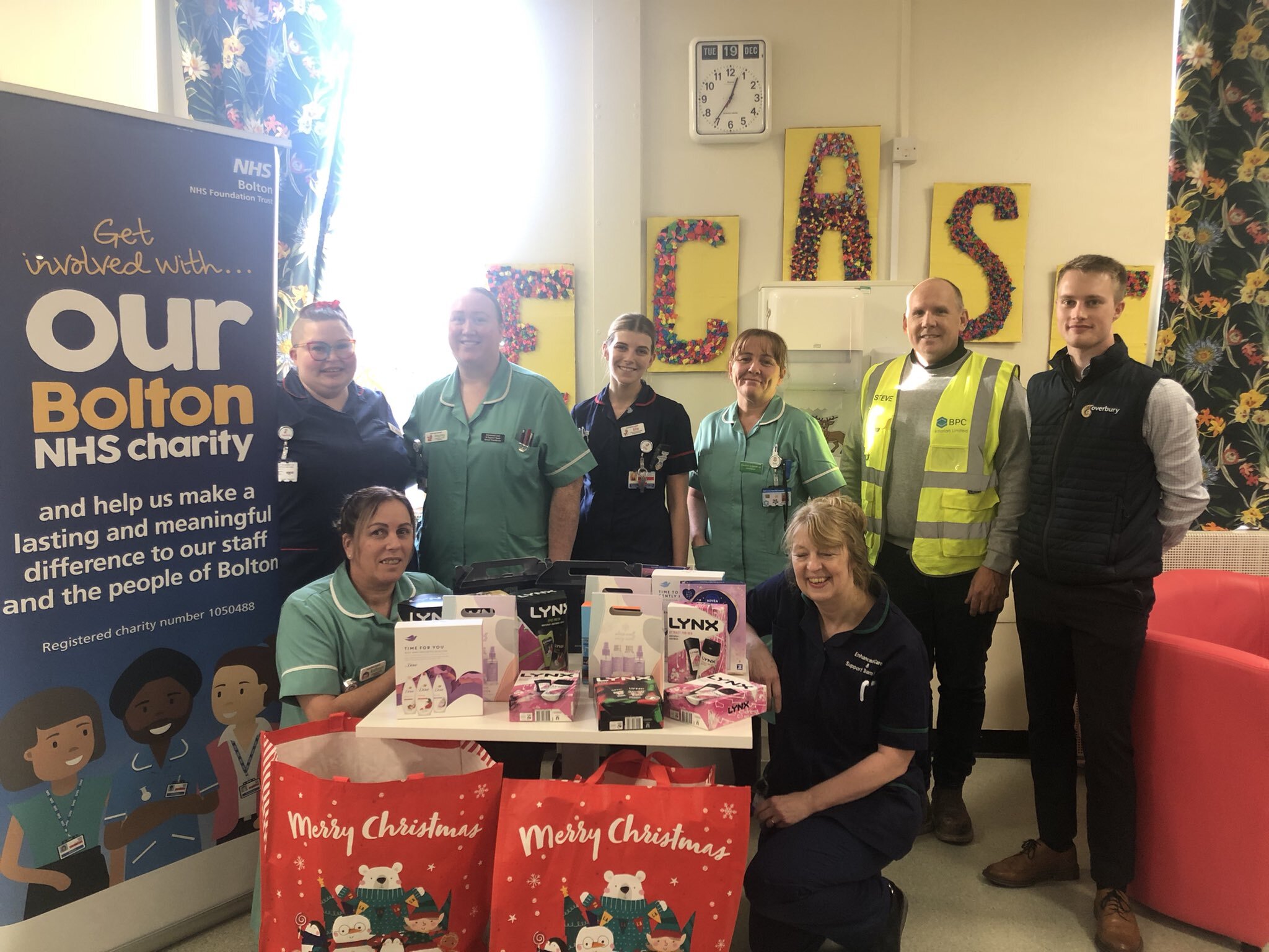 Overbury staff present donated presents to the Enhanced Care and Support Team, ready to distribute to patients