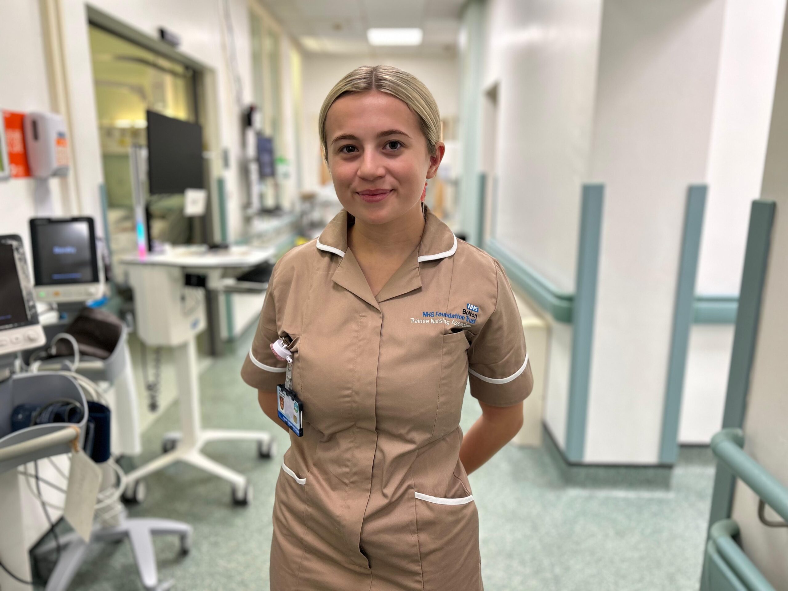 Ellie Edwards, Trainee Nursing Associate, smiles for a picture on Ward C1