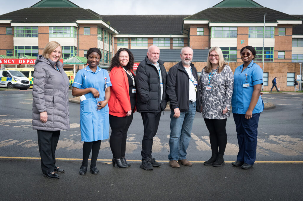 Seven people stood smiling outside Royal Bolton Hospital