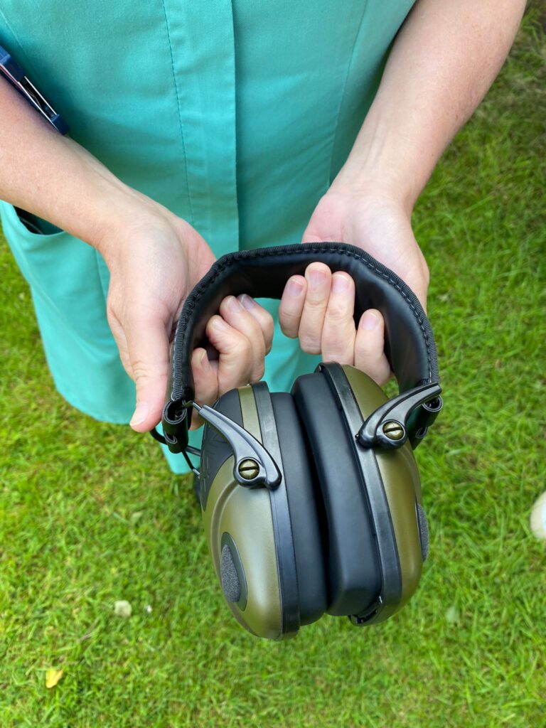 Member of staff holds noise-cancelling headphones