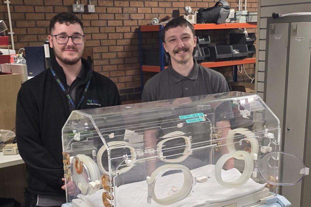 Jon Anderson and Francis Dunne in front of a baby incubator 