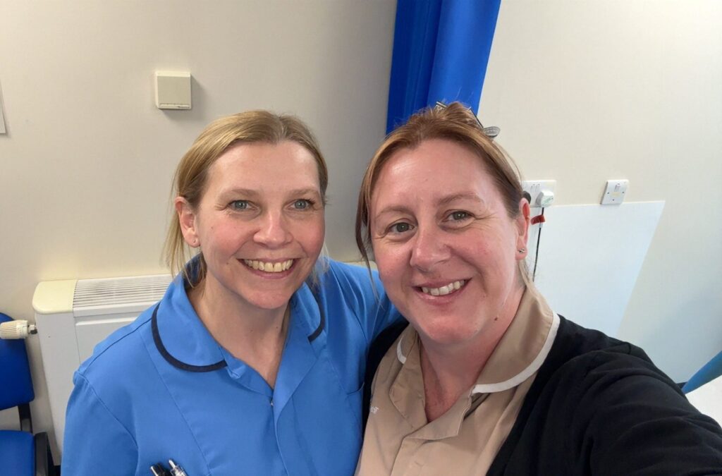 Mindy Orange poses for a selfie with her colleague