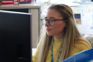 Admin colleague at Bolton NHS Foundation Trust sits at computer carrying out tasks
