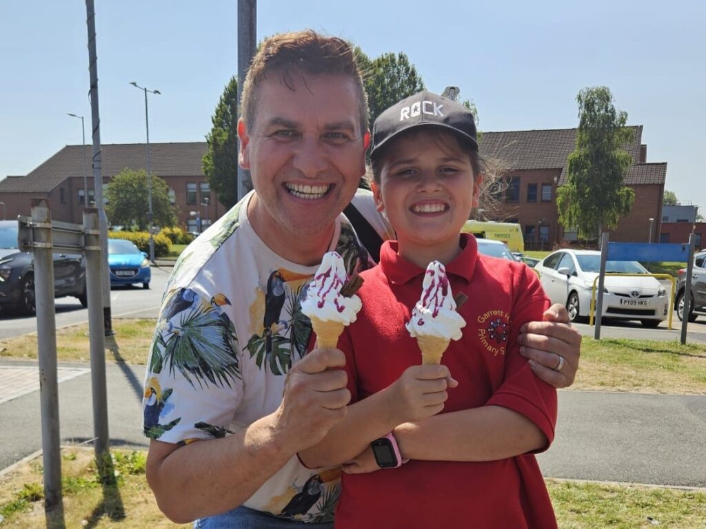 Dad and daughter smile for a photo holding their free ice creams