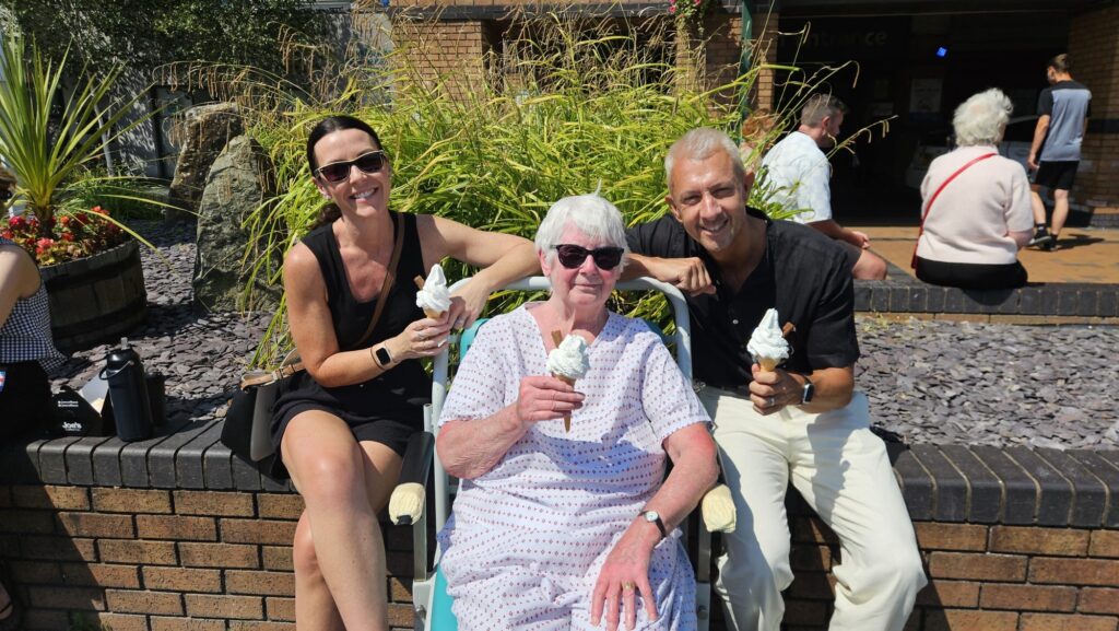 Staff and patients smile for a photo holding their free ice cream